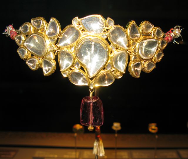 A bazuband to be worn on the front of a princess, made of large diamonds set in gold with a spinel drop in front.