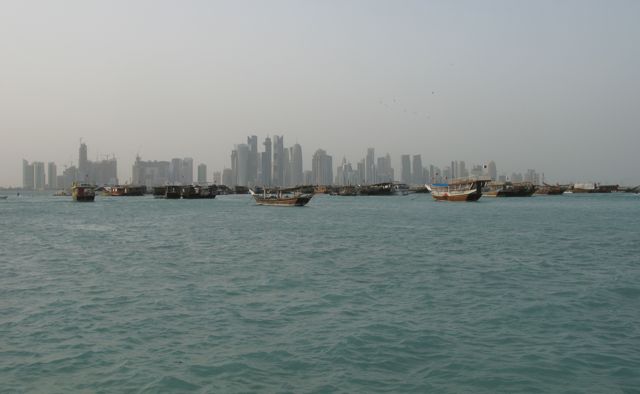 Dhow harbor with ancient boats and modern high rises